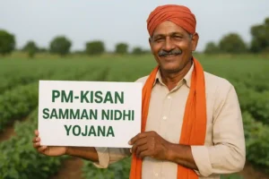 An Indian farmer wearing a beige kurta and orange turban stands smiling in a green agricultural field, holding a white placard with bold green text that reads “PM-KISAN SAMMAN NIDHI YOJANA.”